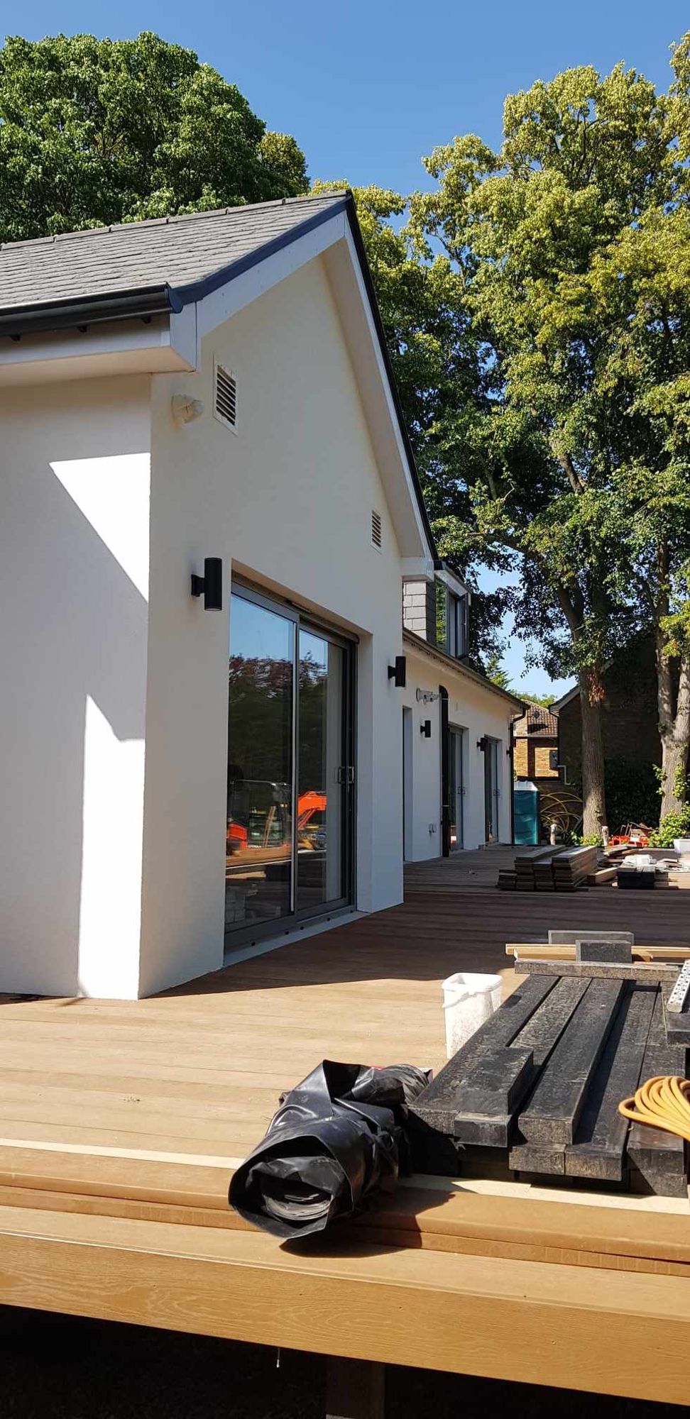 Rendered single-storey garden building with large glazed doors, finished by SANANDR